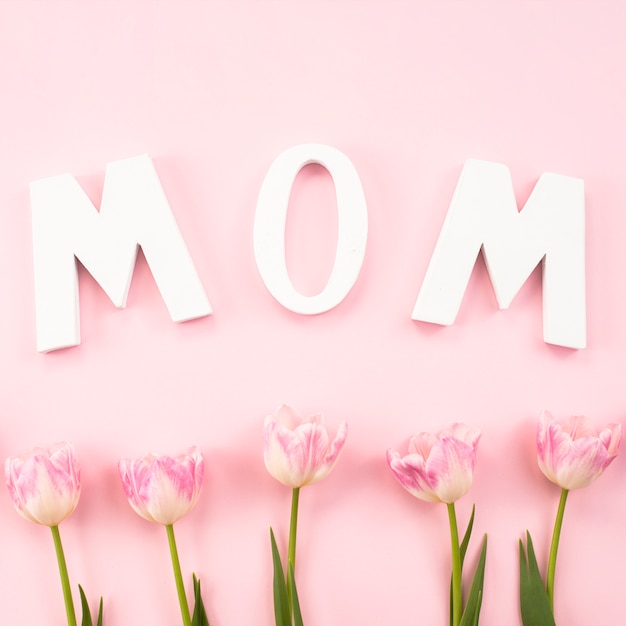 Mom inscription with tulips on table