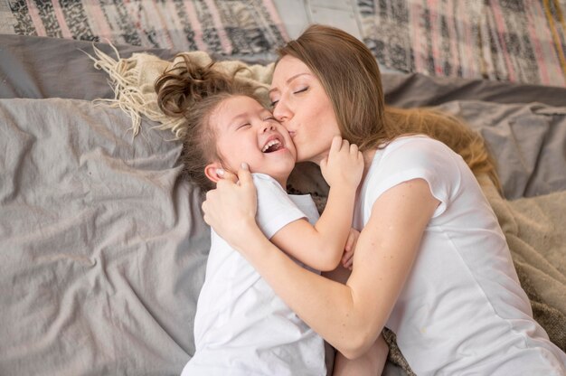 Mom kissing little girl