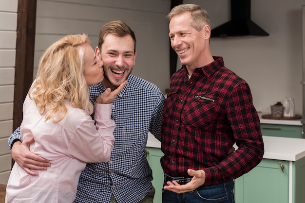 Free photo mom kissing son in the kitchen