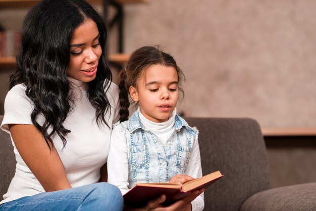 Mom listening her daughter while reading