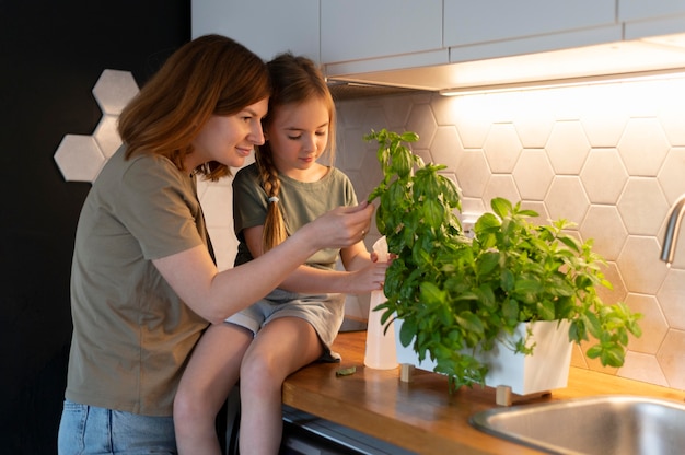 그녀의 딸에게 식물을 돌보는 방법을 보여주는 엄마