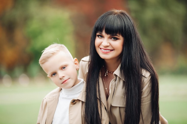 Mom and son are on good terms walking in the park chatting Stylish family family look