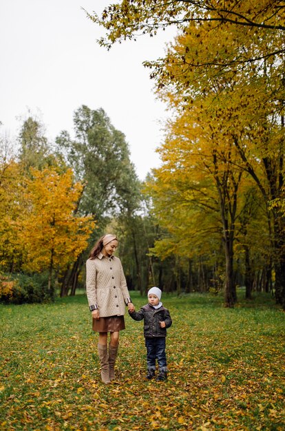 Mom and son walking and having fun together in the autumn park.