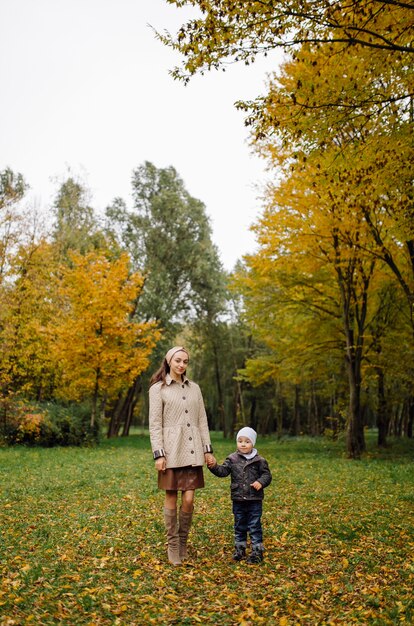 Mom and son walking and having fun together in the autumn park.