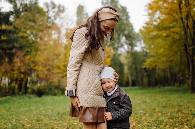 Mom and son walking and having fun together in the autumn park.