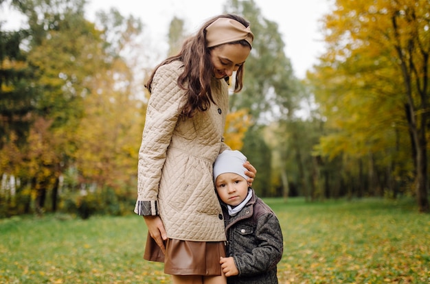 Mom and son walking and having fun together in the autumn park.