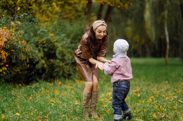 Mom and son walking and having fun together in the autumn park.