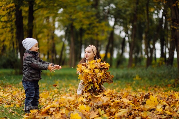 Mom and son walking and having fun together in the autumn park.