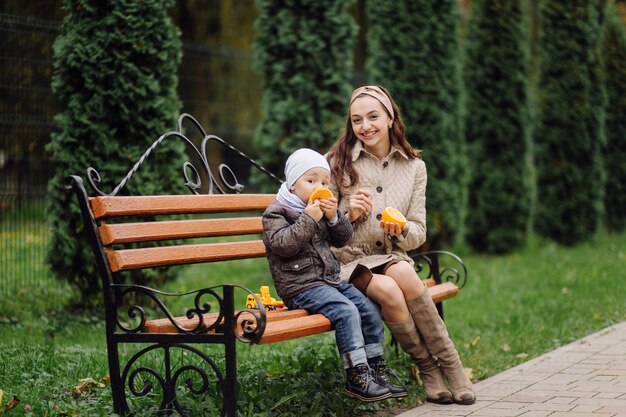 Mom and son walking and having fun together in the autumn park.