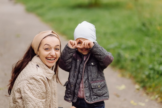 Mamma e figlio che camminano e si divertono insieme nel parco d'autunno.