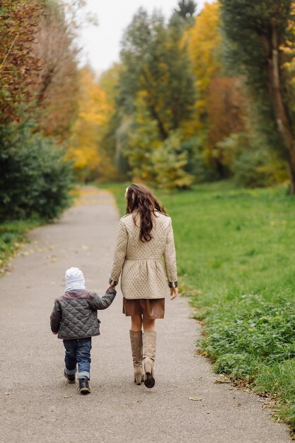 Mom and son walking and having fun together in the autumn park.