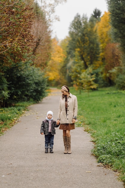 Mom and son walking and having fun together in the autumn park.