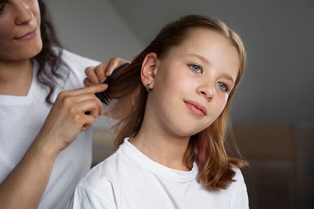 Mom taking care of  her daughter's hair