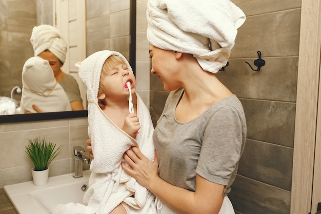 Mom teaches little son to brush his teeth