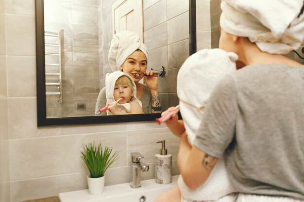 Mom teaches little son to brush his teeth