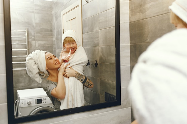 Mom teaches little son to brush his teeth