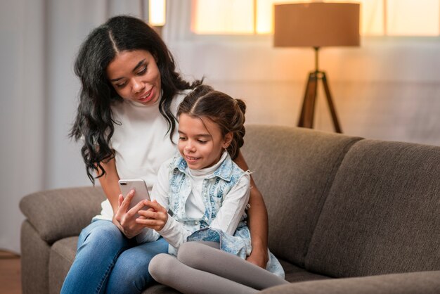 Mom teaching daughter to use mobile