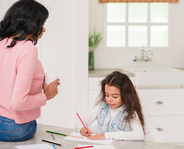 Mom watching daughter coloring