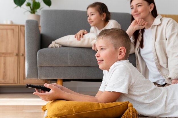 Mom watching television with her children