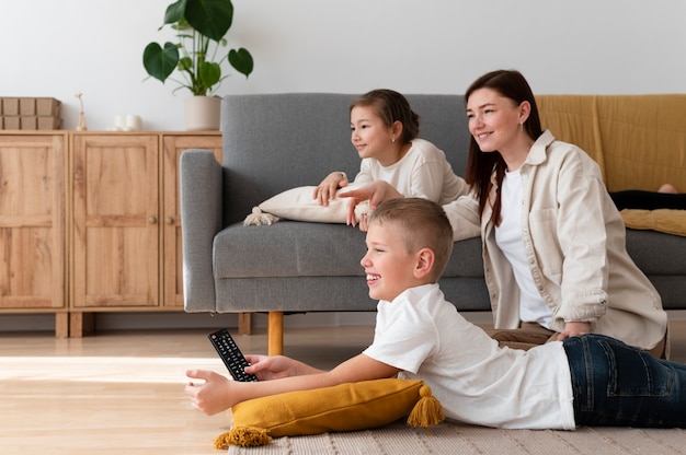 Free photo mom watching television with her children