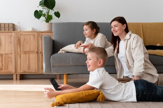 Mom watching television with her children