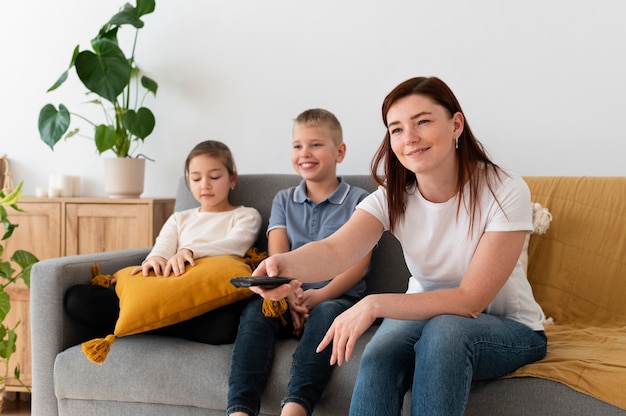 Бесплатное фото Мама смотрит телевизор со своими детьми