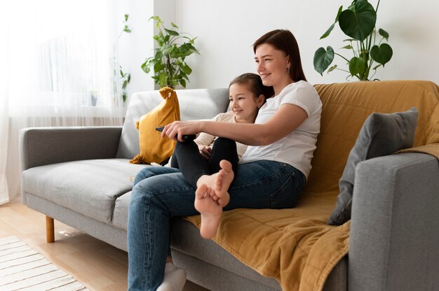 Mom watching television with her children