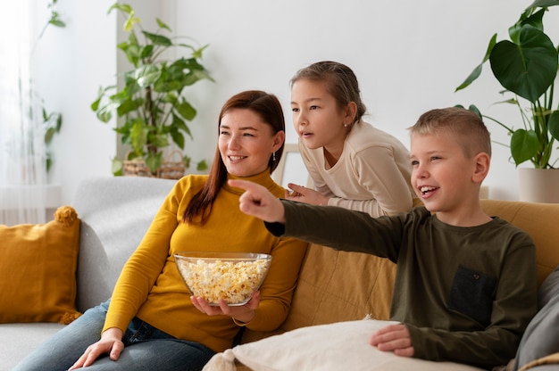 Mom watching television with her children