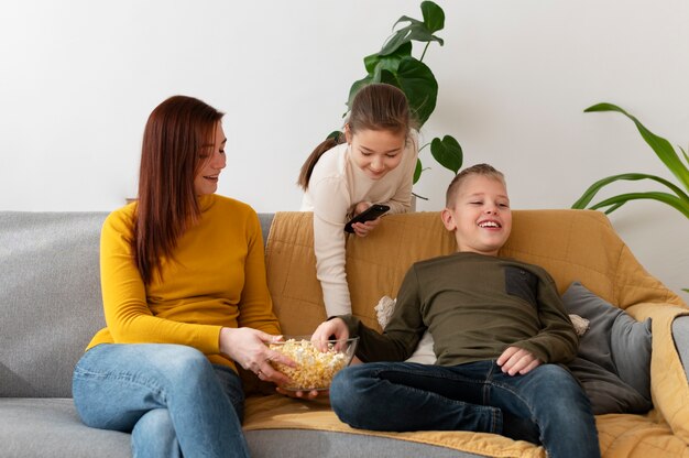 Mom watching television with her children