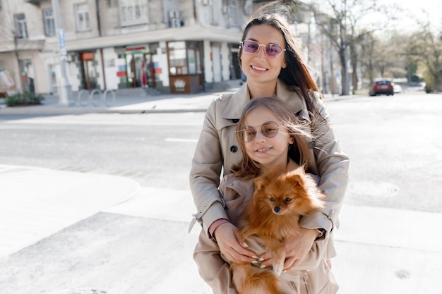 mom with daughter and dog in city street outdoor