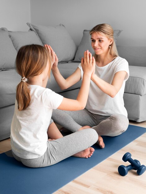 Mom with girl exercise on mat