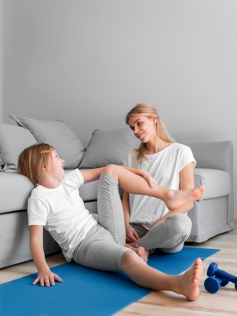 Mom with girl workout on mat