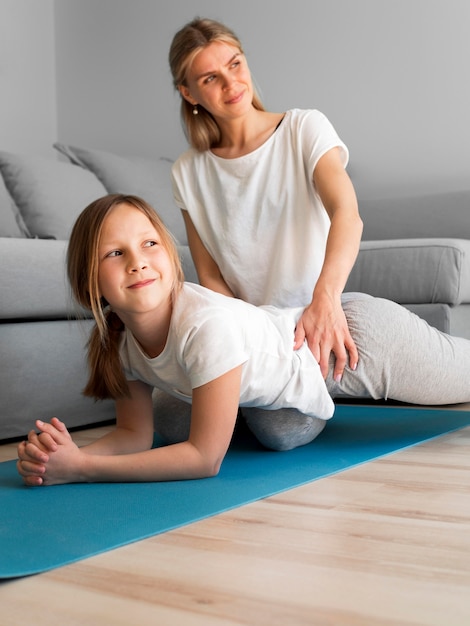 Foto gratuita mamma con ragazza allenamento esercizio di resitenza