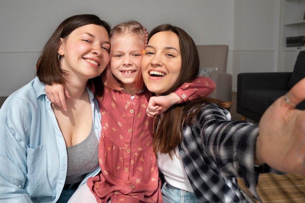 Free photo mommies spending time together with their daughter at home