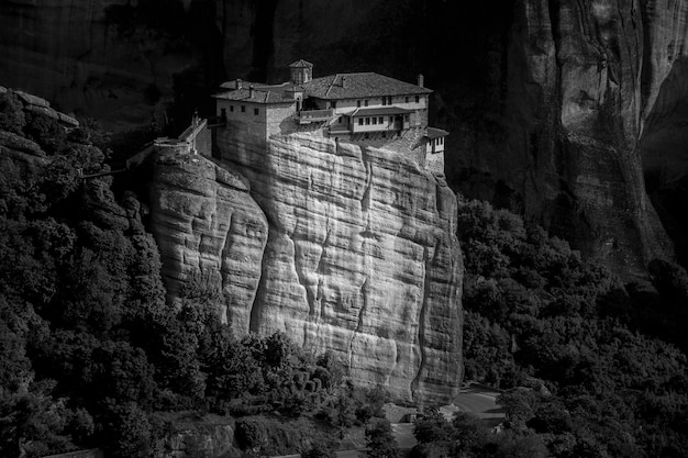 Monastery of the Holy Trinity on a rock surrounded by forests and hills under sunlight in Greece