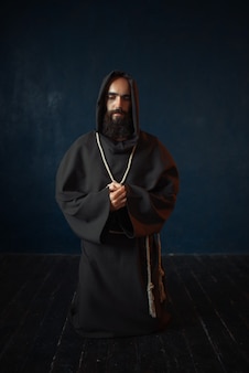 中世の僧侶が黒いローブをまとい フードを閉じて目を閉じて祈る 秘密の儀式 ダークケープの神秘的な修道士 謎と精神性 プレミアム写真 中世の僧侶が黒いローブをまとい フードを閉じて目を閉じて祈る 秘密の儀式 ダークケープの神秘的な修道士 謎と精神性 プレミアム写真