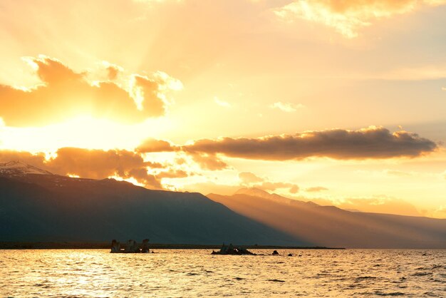 Mono Lake sunset with light ray through mountains.