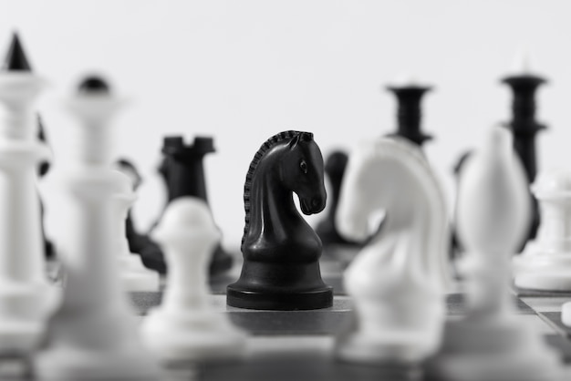 Free photo monochrome chess pieces with game board