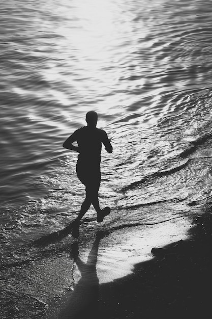 Monochrome portrait of man jogging on the beach