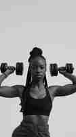 Free photo monochrome portrait of woman working out with weights