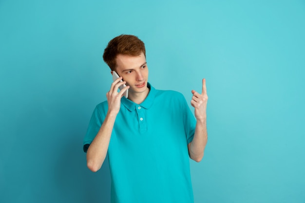 Monochrome portrait of young man on blue background