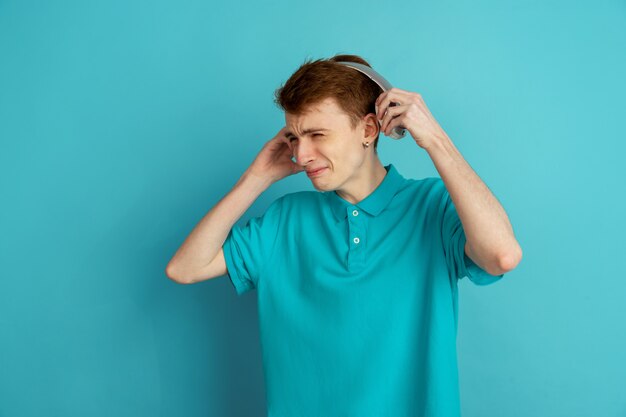 Monochrome portrait of young man on blue background