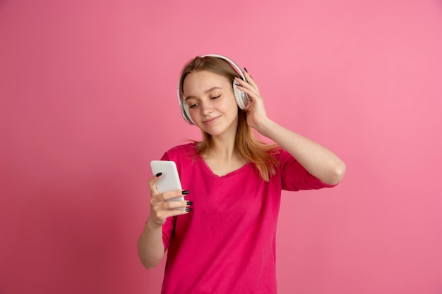 Monochrome portrait of young woman on pink background