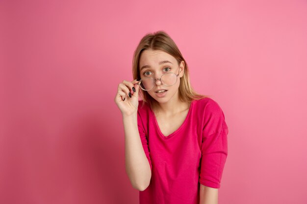 Monochrome portrait of young woman on pink background