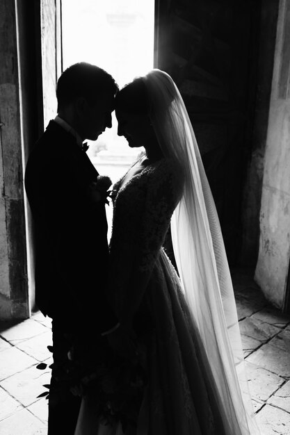 Monochrome tender photo of a wedding couple who is nearly kissing