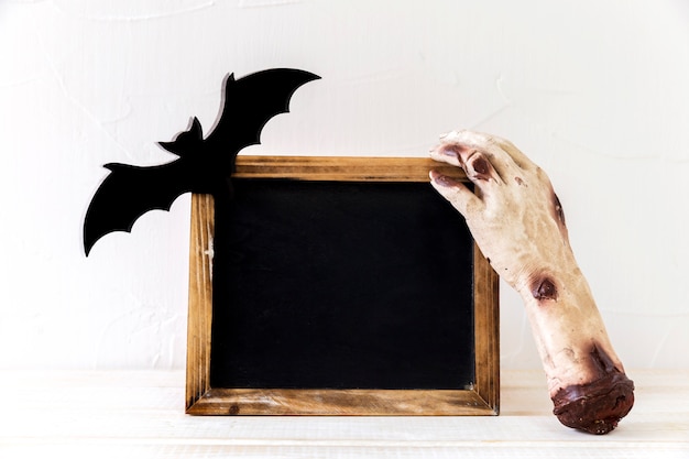 Monster hand and bat near chalkboard