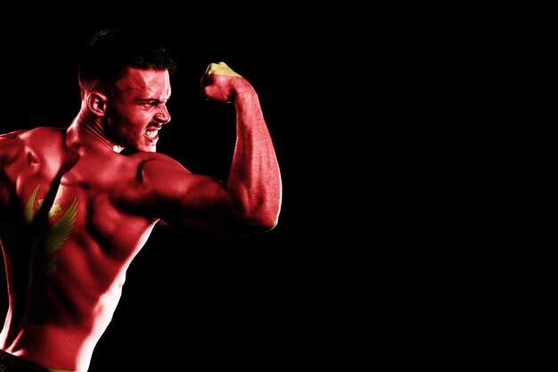 Montenegro flag on handsome young muscular man black background