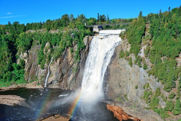 Montmorency Falls with rainbow and blue sky near Quebec City.
