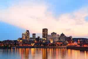 Free photo montreal over river at sunset with city lights and urban buildings