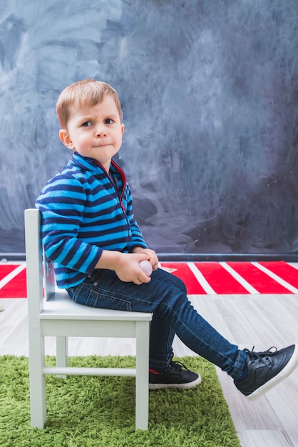 Moody boy sitting on chair